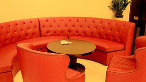Ein rotes, bezogenes Sofa mit einem runden Tisch in der Mitte.