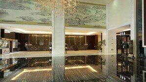 Eine moderne Hotelhalle mit einem spiegelnden Boden, einer Treppe und einem ISA-Bank.