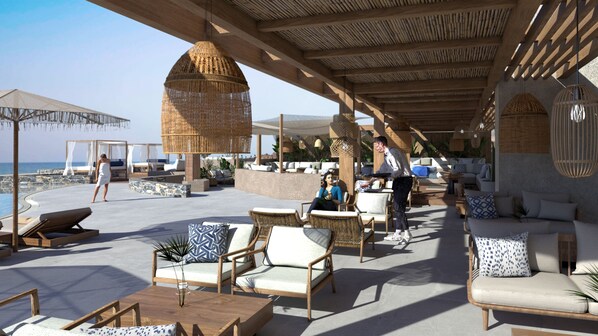 A covered outdoor seating area with wicker furniture, a pool, and a view of the sea. - Unique Blue Resort (Hersonissos)