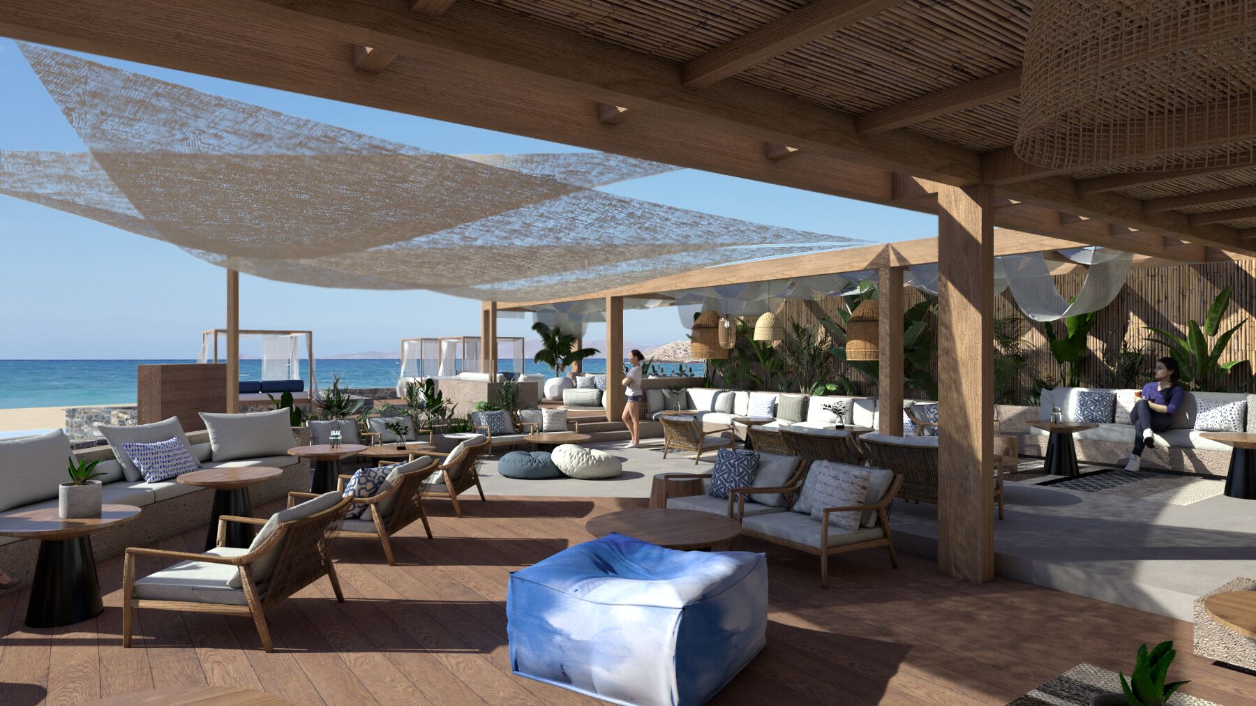 An outdoor lounge area with seating, tables, and umbrellas, overlooking a beach.