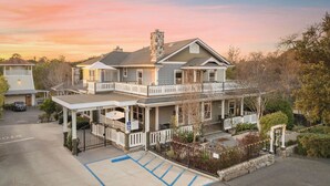 A two-story house with a balcony, a covered porch, and a parking area with handicapped accessibility.