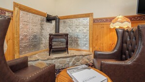 A cozy corner with a fireplace, leather chairs, and a table with a book.