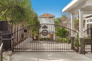 A gated entrance with a star emblem, a wooden door, and a small porch with a tiled roof.