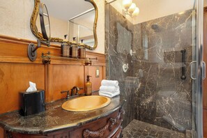 A bathroom with a wooden vanity, a marble sink, a large mirror, and a glass-enclosed shower. - Demetria by Polo House and Bungalows (Santa Ynez)