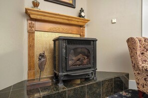 A traditional fireplace with a mantel, a clock, and a decorative urn. - Demetria by Polo House and Bungalows (Santa Ynez)
