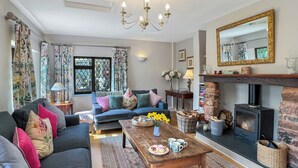 Un salon chaleureux avec un canapé, une table basse, une cheminée et un grand miroir.
