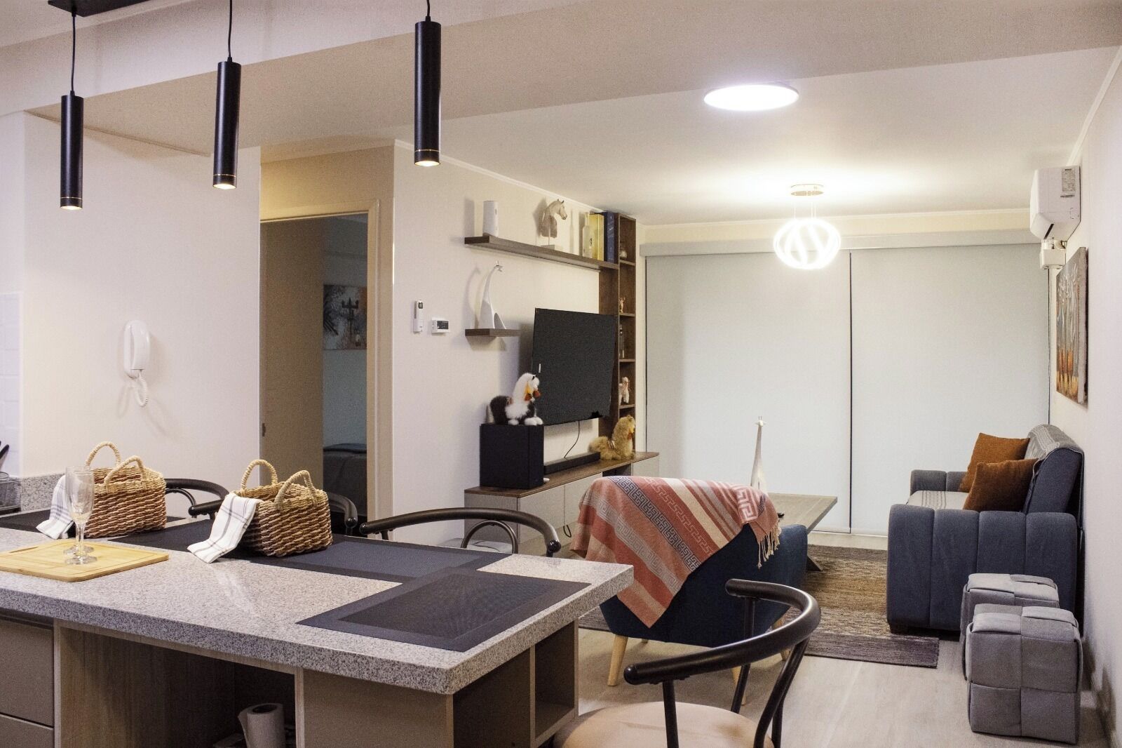 A modern living space with a kitchen area, dining table, and seating area.