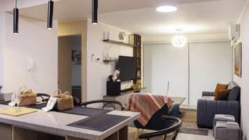 A modern living space with a kitchen area, dining table, and seating area.