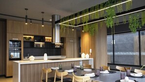 A modern kitchen with a central island, wooden chairs, and a dining table set for four.