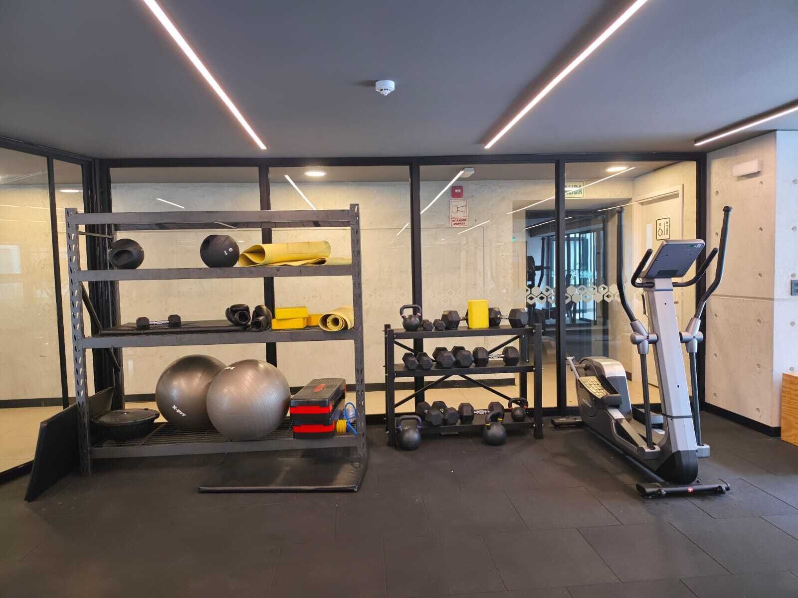 A gym with exercise equipment, a treadmill, and a weight rack.