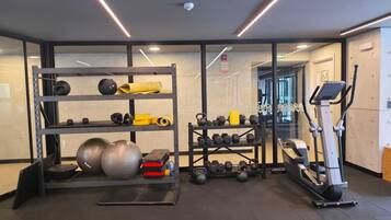 A gym with exercise equipment, a treadmill, and a weight rack.