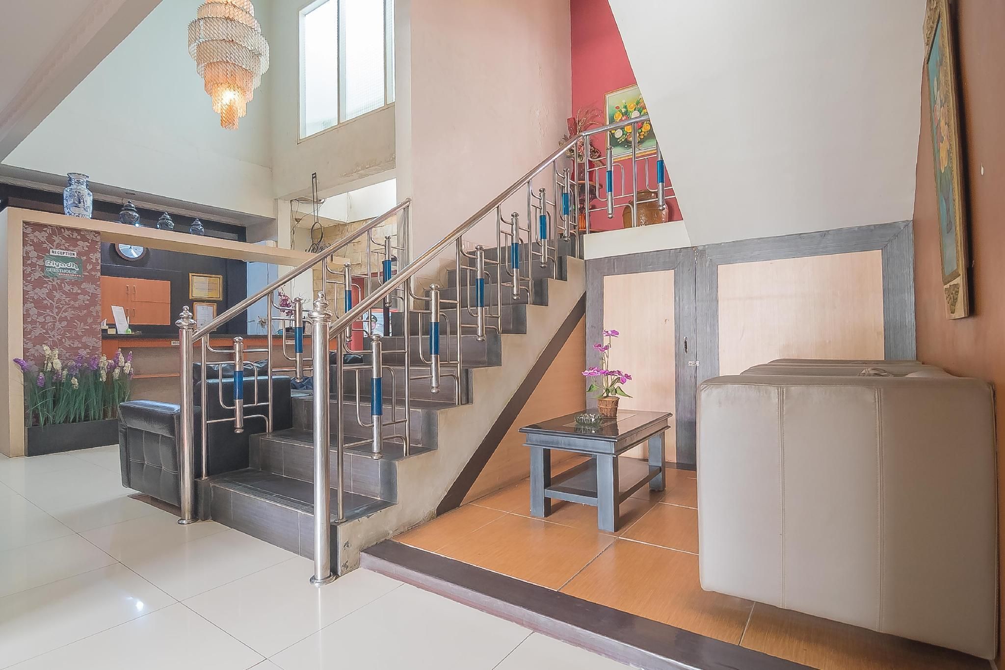 A staircase with metal railings and a potted plant at the bottom.