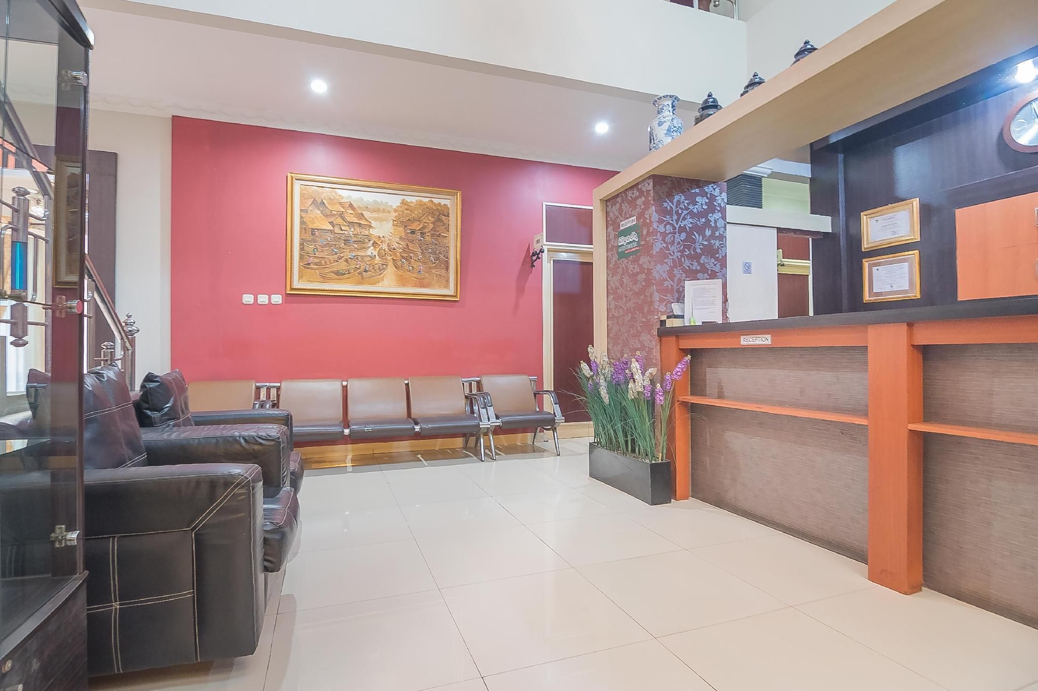 A reception area with a reception desk, a bench seating area, and a large framed artwork on the wall.