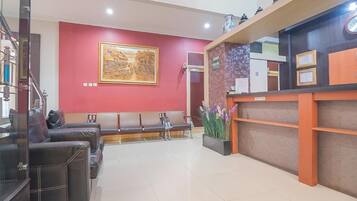 A reception area with a reception desk, a bench seating area, and a large framed artwork on the wall.