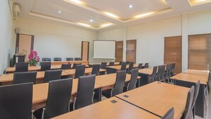 A conference room with multiple tables, chairs, a whiteboard, and a projector screen. - Formerly Reddoorz Syariah Plus @ Banjarbaru 2 (Banjarbaru)