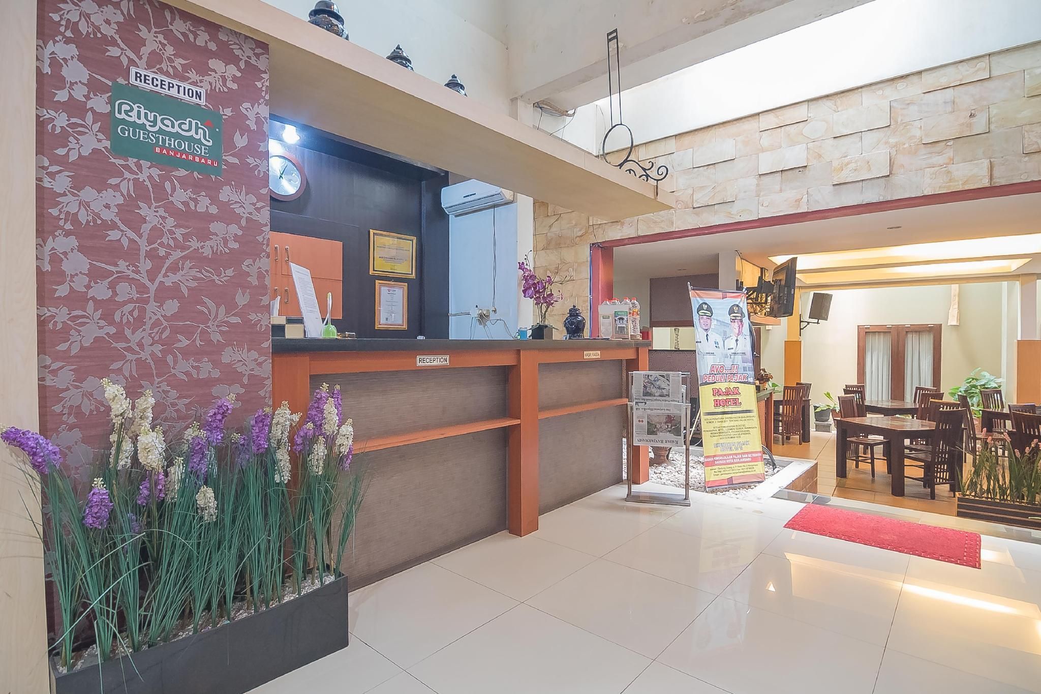 A reception area with a reception desk, a clock, a framed certificate, and a poster.
