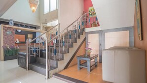 A staircase with metal railings and a potted plant at the bottom. - Formerly Reddoorz Syariah Plus @ Banjarbaru 2 (Banjarbaru)