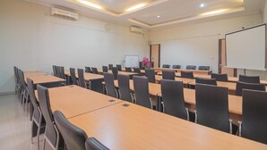 A conference room with multiple tables and chairs, a whiteboard, and an air conditioning unit on the ceiling. - Formerly Reddoorz Syariah Plus @ Banjarbaru 2 (Banjarbaru)