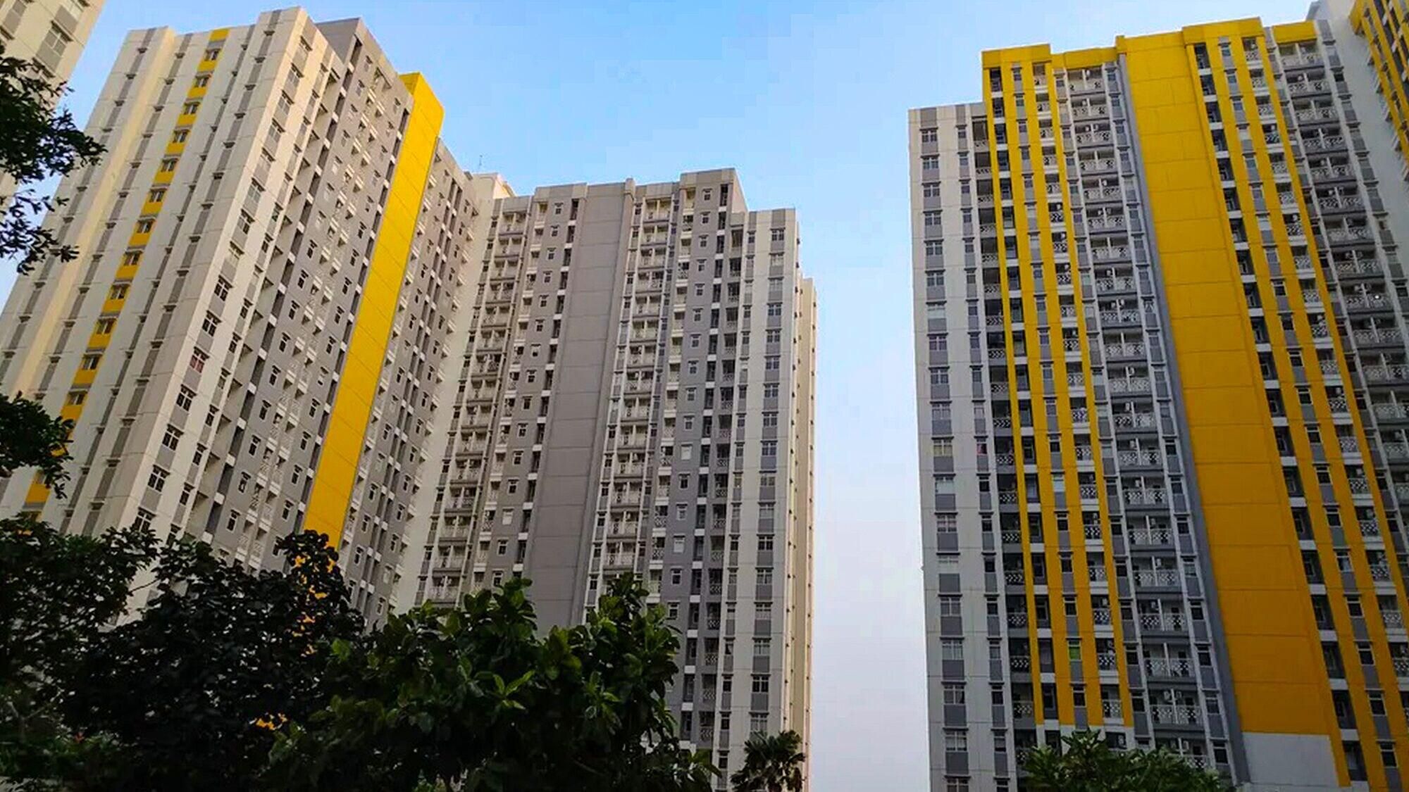 High-rise residential buildings with multiple balconies and a clear sky.