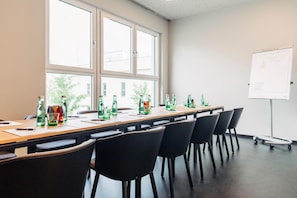 A conference room with a long table, chairs, and a whiteboard. - Harry's Home Steyr Hotel (Alberndorf in der Riedmark)