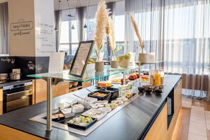 A buffet setup with various food items and a menu stand.
