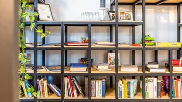 A bookshelf with books, a framed certificate, and a small plant.