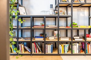A bookshelf with books, a framed certificate, and a small plant.