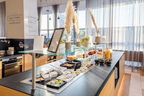 En buffetopstilling med forskellige retter og en menustativ.