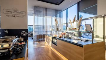 A modern breakfast bar with a view, featuring a menu board, decorative pampas grass, and a variety of breakfast items.