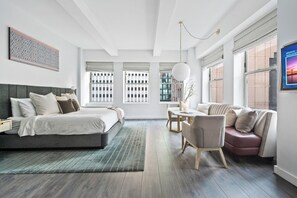 Une chambre moderne comprenant un lit, une table de chevet et un coin salon avec une table et des chaises.