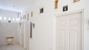 Un pasillo con puertas blancas, una pequeña mesa y un cartel que indica el número de habitación 8.