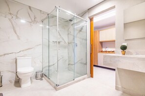 A bathroom with a glass-enclosed shower, a toilet, and a sink area with a potted plant. - Conforto no Ã®le de Pipa por Carpediem (Tibau do Sul)