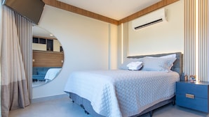 A modern bedroom with a bed, bedside table, and a mirror. - Conforto no île de Pipa por Carpediem (Tibau do Sul)