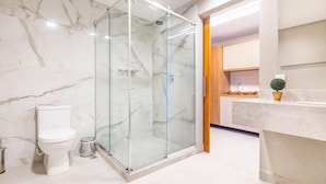 A bathroom with a glass-enclosed shower, a toilet, and a sink area with a potted plant. - Conforto no île de Pipa por Carpediem (Tibau do Sul)