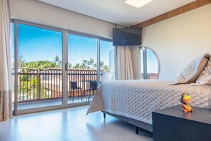A bedroom with a bed, a TV, a desk, and a view of the outdoors. - Conforto no Ã®le de Pipa por Carpediem (Tibau do Sul)