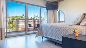 A bedroom with a bed, a TV, a desk, and a view of the outdoors. - Conforto no île de Pipa por Carpediem (Tibau do Sul)