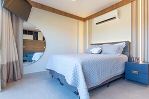 A modern bedroom with a bed, bedside table, and a mirror. - Conforto no Ã®le de Pipa por Carpediem (Tibau do Sul)