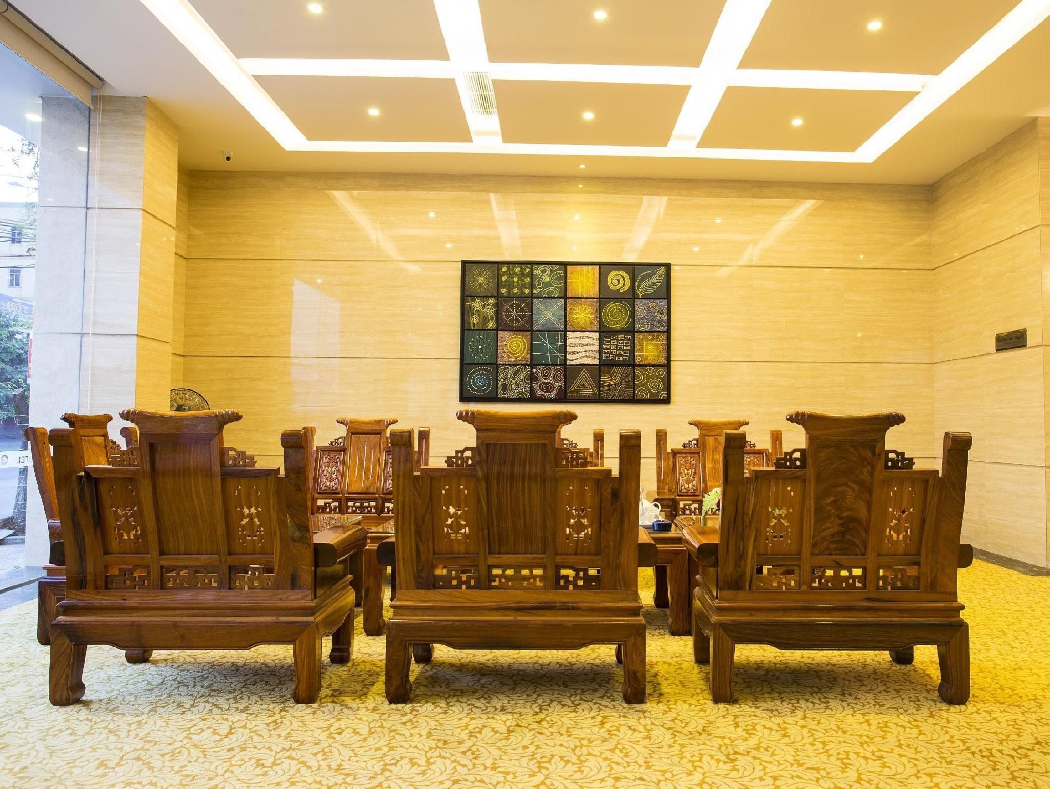A room with wooden furniture, a patterned wall, and a ceiling with recessed lighting.