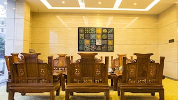 A room with wooden furniture, a patterned wall, and a ceiling with recessed lighting.