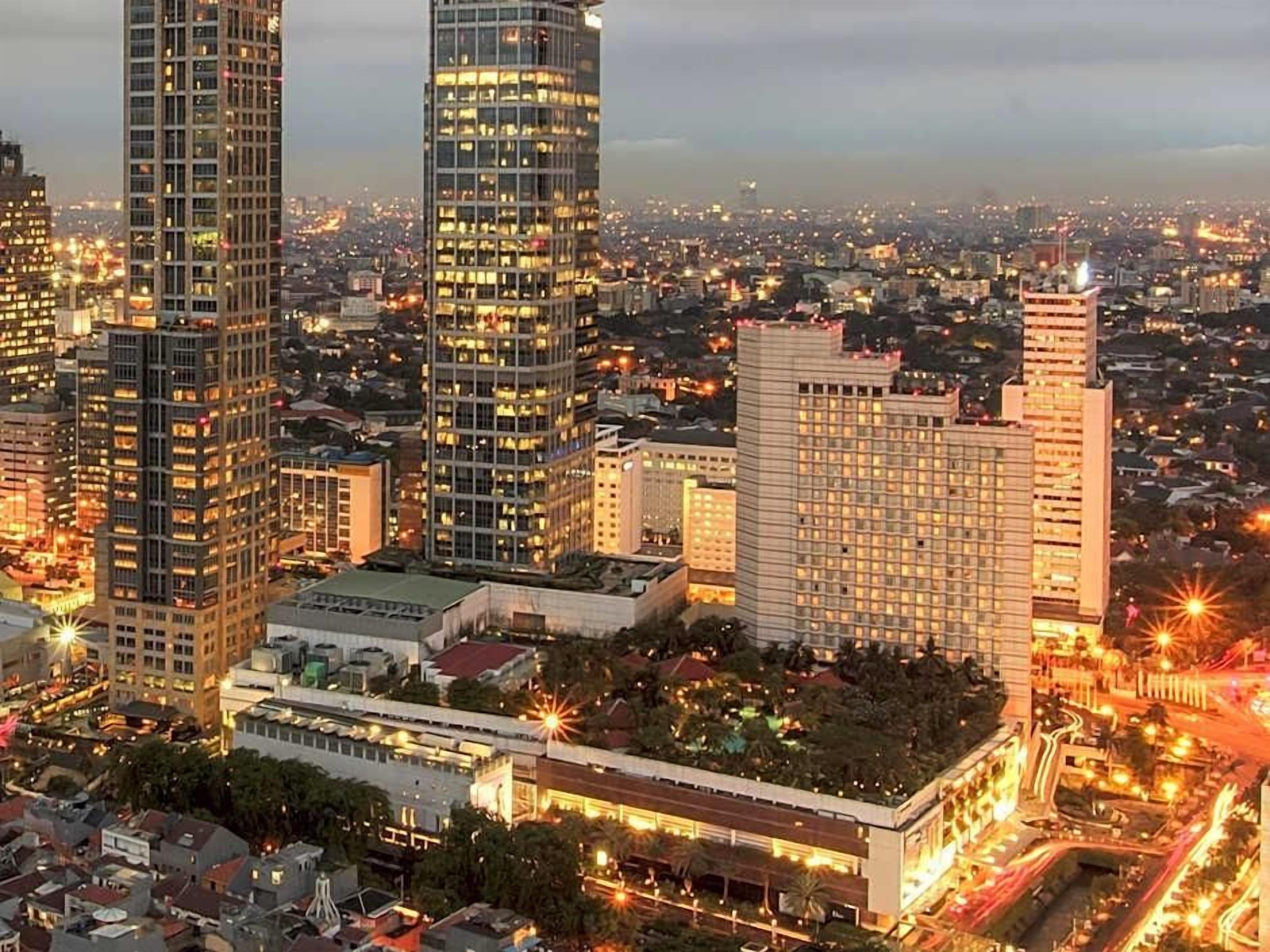 A cityscape with high-rise buildings, one with a distinctive curved top.