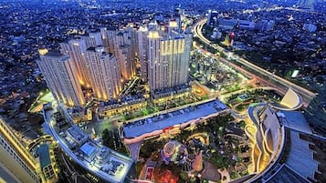 A high-rise building complex with multiple floors, surrounded by a well-lit urban area with roads and greenery.