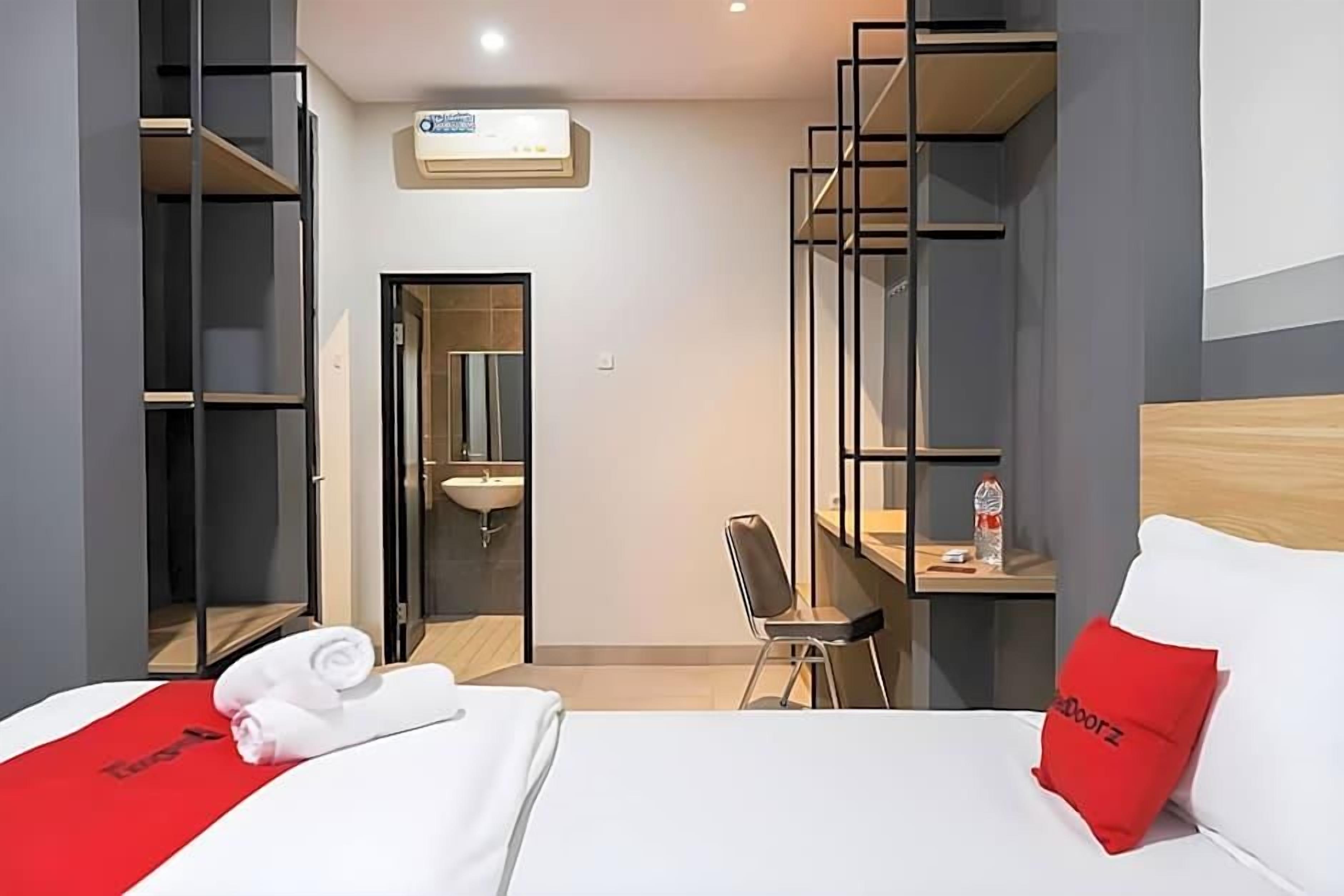 Une chambre d’hôtel comprenant un lit, un bureau, une chaise, une armoire et une salle de bain.