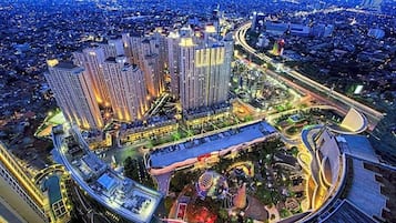A high-rise building complex with multiple floors, surrounded by a well-lit urban area with roads and greenery.