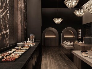 A modern interior with a marble wall, a buffet with various food items, and elegant chandeliers. - Ammades All Suites Beach Hotel - Adults Only (Rhodes)