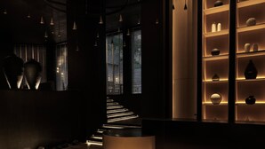 A modern interior with a wooden staircase, pendant lighting, and a display of vases. - Ammades All Suites Beach Hotel - Adults Only (Rhodes)