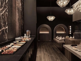 Un interior moderno con una larga mesa de buffet, arcos y una iluminación decorativa.