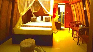 A cozy bedroom with a bed, a nightstand, a chair, and a small table. - Bunbulan Cottage Lake View (Kintamani)
