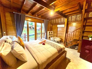 A wooden interior with a bed, a staircase, and a view of the outdoors.