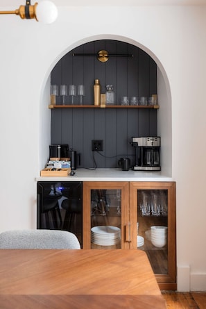 A compact kitchen with a built-in coffee station, a dining table, and a seating area. - Executive Suite/ Walkable/ Free Parking/ Office #5 (Lakewood)