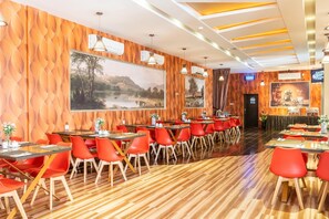 Ein Restaurant mit Holzwänden, roten Stühlen und Tischen.